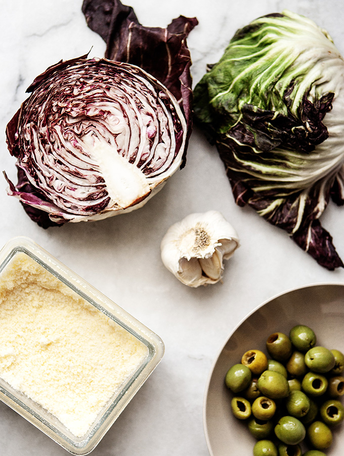 The tartness of the Italian Radiccio is softened by a creamy green Castelvetranos olive dressing along with the saltiness of Parmeasan cheese- Radicchio Salad with Green Olive Dressing a salad to love. RADICCHIO Radicchio is an Italian green that is in the chicory family. It comes in many varieties, but my favorite is the beautiful heads with green tinged leaves, Radicchio di Choiggia, the tight heads with beautiful purple-pink leaves, this is what you most often see at the famers markets. My favorite is Radicchio de Vento, with its delicate pink leaves, make a lovely salad, grab it when you can find it. GREEN OLIVE DRESSING The finely grated olives create a creamy dressing for the crisp Radicchio along with some garlic, olive oil, mild vinegar and lots of gratedParmesan cheese. RADICCHIO SALAD A simple salad that packs a punch. The radicchio creates the punch and the creamy green olive dressing tones tings down added with the saltiness of the Parmesan cheese -Prego! Radicchio Salad with Green Olive Dressing |Bijouxs Little Jewels 